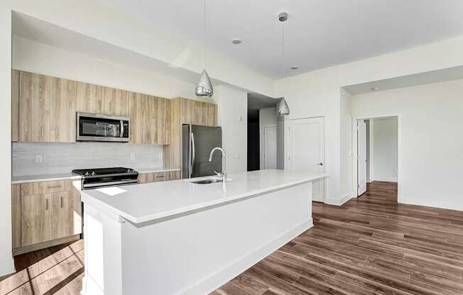 A modern kitchen with a white countertop and wooden cabinets.