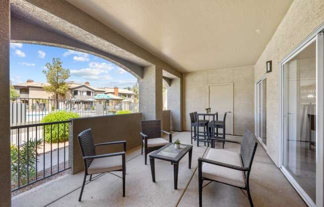 a patio with a table and chairs and a balcony