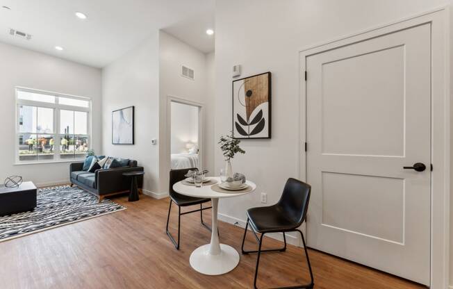 an open living room with white walls and wooden floors and a white door