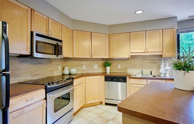 A kitchen with wooden cabinets and a stovetop oven.