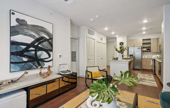 A modern kitchen with a large painting on the wall.