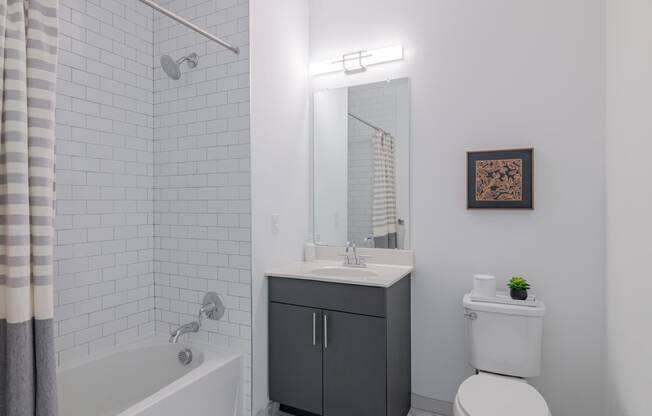 a white bathroom with a tub and a sink and a toilet