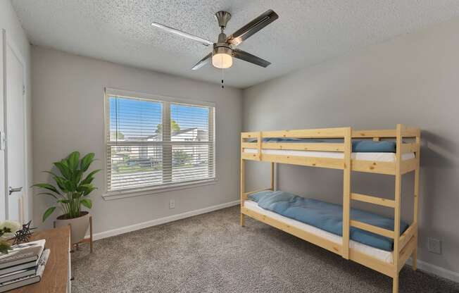 a bedroom with bunk beds and a ceiling fan