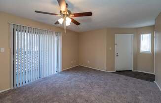 A room with a ceiling fan and carpeted floor.