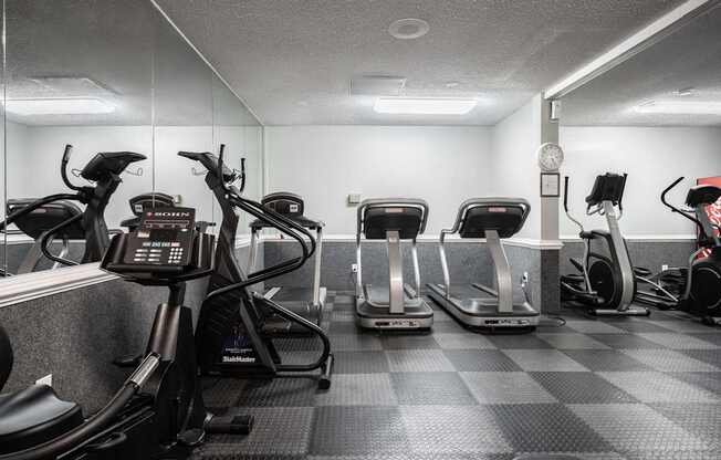 A gym with treadmills, elliptical machines, and a weight machine.