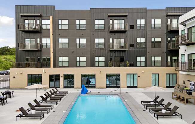 A large black building with a pool in front.