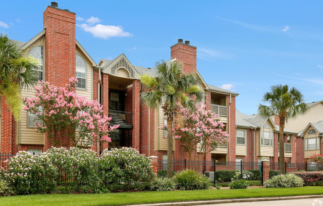 a row of houses with palm trees and flowering plants