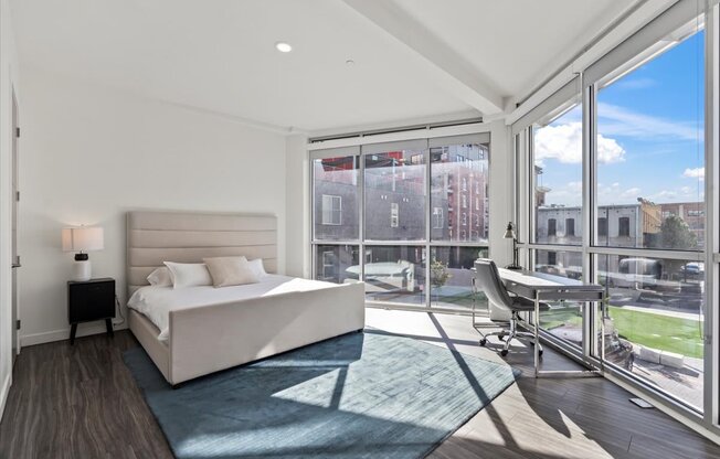 A bedroom with a large bed and a view of the outside.
