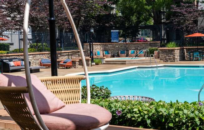 a swimming pool with a swinging chair next to it