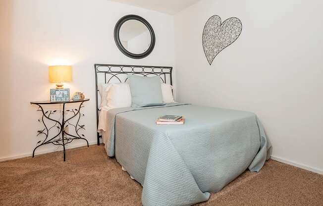 a bedroom with a bed and a nightstand with a lamp