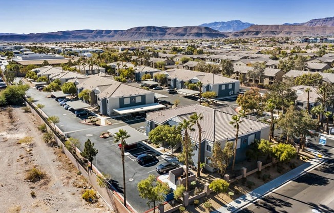 an aerial view of a subdivision in the desert with mountains in the background