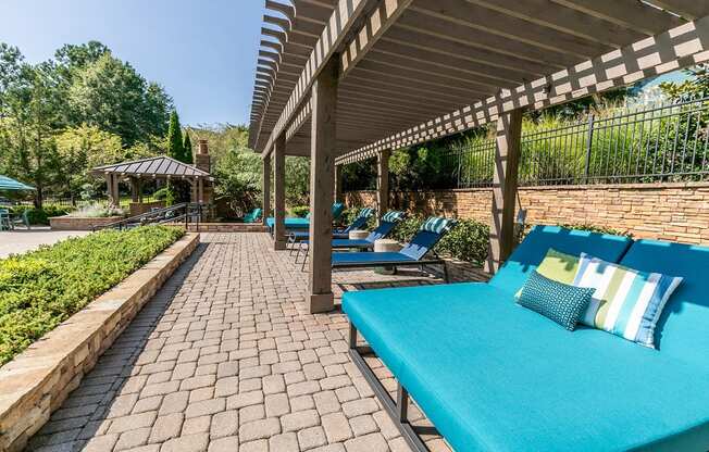 a patio with blue couches and chairs and a pavilion