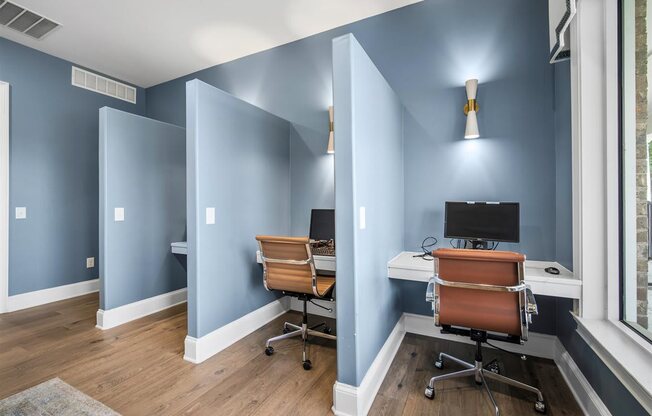 A room with two chairs and two desks.