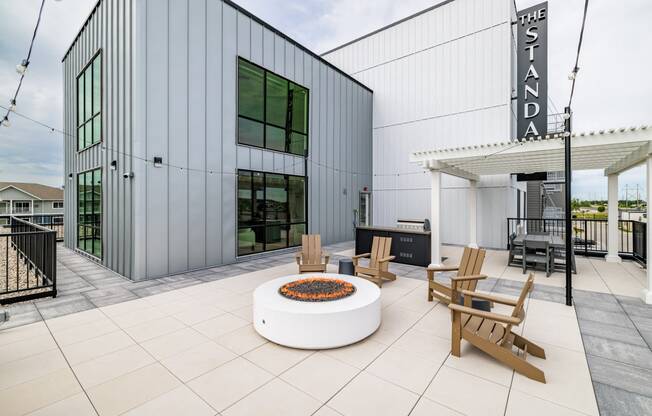 a patio with a fire pit and chairs outside of a building at The Standard on 32nd, West Fargo, ND