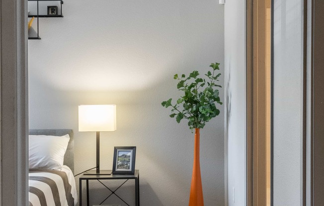 a bedroom with a bed and a vase with a plant