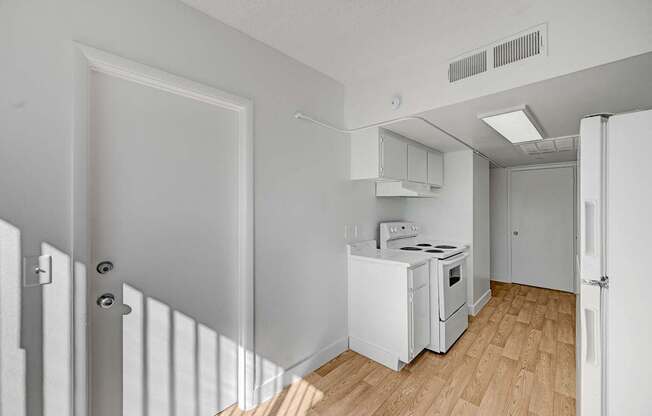 A small white kitchen with a stove and oven.