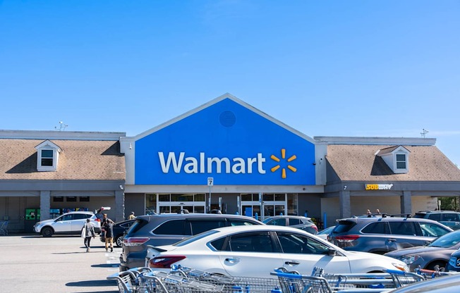 A Walmart store with cars parked in front.