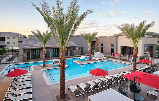 a swimming pool with chairs and palm trees