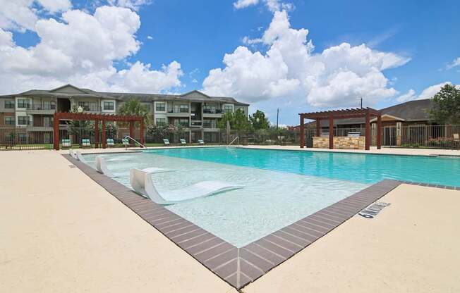 A large swimming pool in front of apartment buildings.
