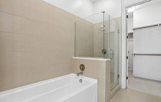 A bathroom with a white bathtub and a glass enclosed shower at Knox Heights Apartments in Dallas, TX