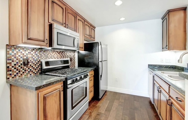 a kitchen with wooden cabinets and stainless steel appliances