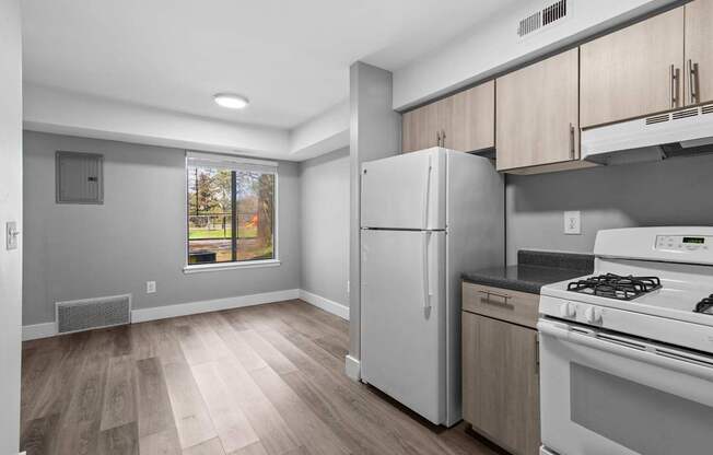 A kitchen with a white fridge and stove top oven.