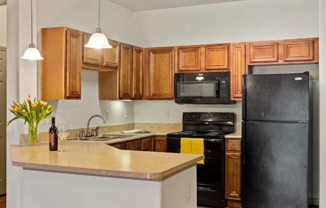 a kitchen with wood cabinets and black appliances