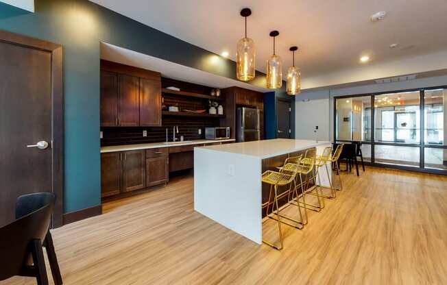 a kitchen with a large white island and yellow chairs