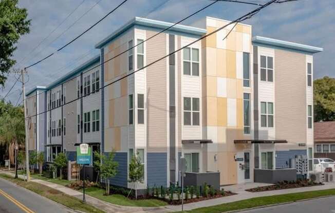 A modern apartment building with a blue and beige facade.