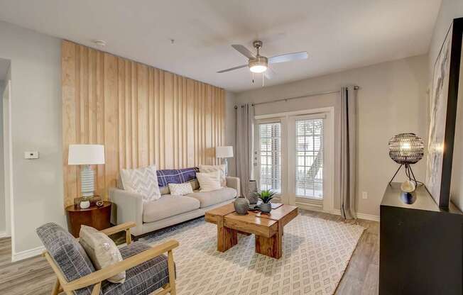 A living room with a couch, chair, and a rug.