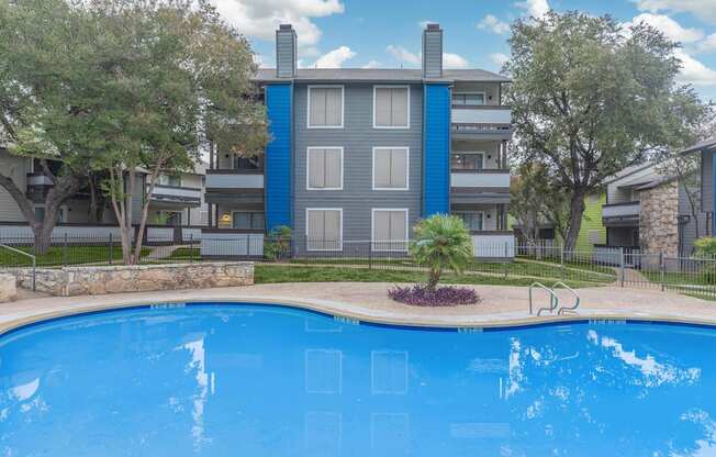 a large swimming pool with an apartment building in the background
