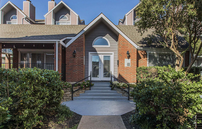 A brick building with a white door and a small porch.