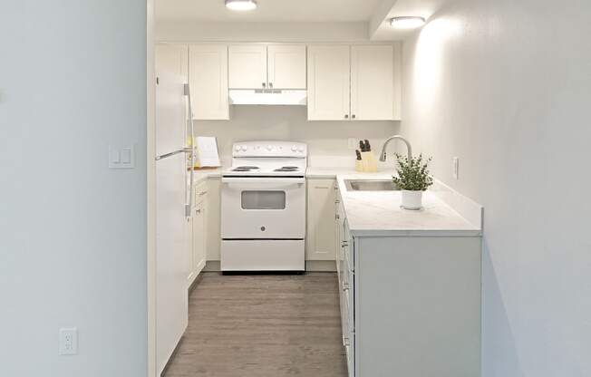 a white kitchen with white appliances and white cabinets