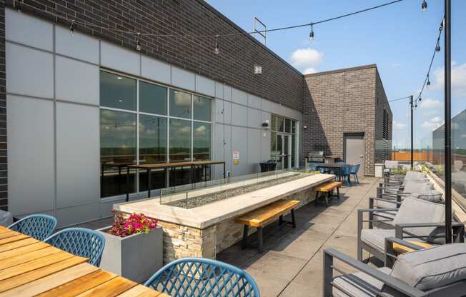 a patio with tables and chairs and a building with large windows