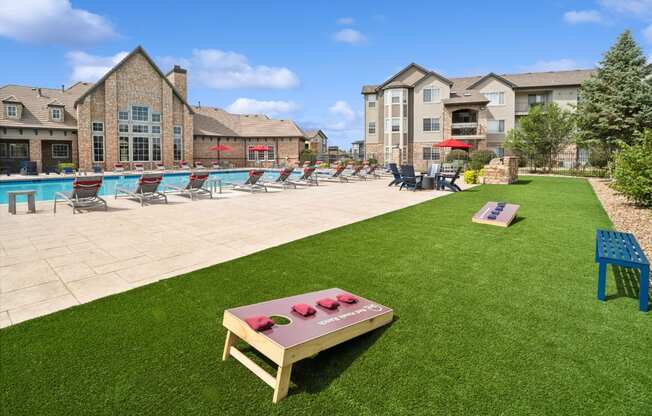 lawn with cornhole games at Red Hawk Ranch apartments