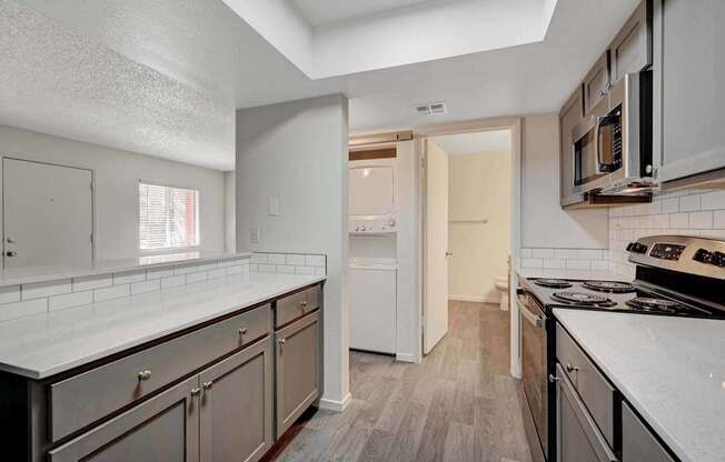 A kitchen with white countertops and stainless steel appliances.