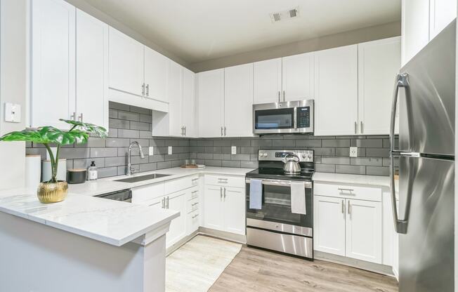 a kitchen with white cabinets and stainless steel appliances