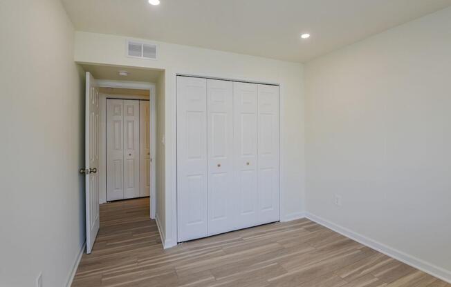 A room with a white door and a white closet.