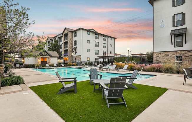 A swimming pool surrounded by lawn chairs and buildings.