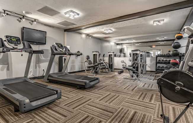 A gym with treadmills, exercise bikes, and other equipment