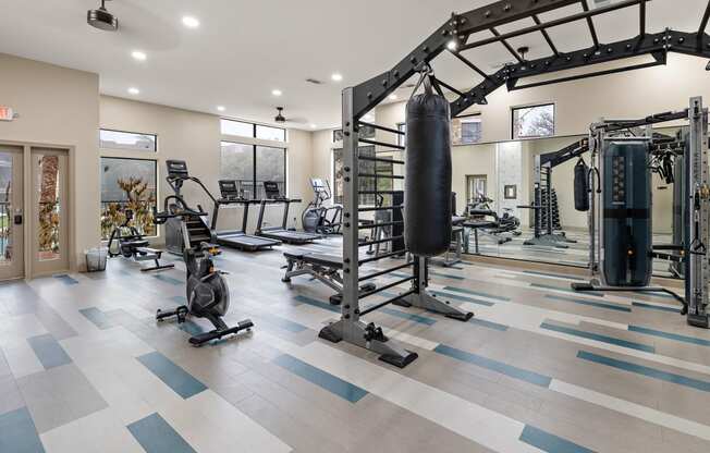 a gym with weights and cardio equipment and a punching bag