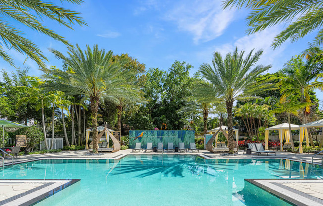 a swimming pool with palm trees and umbrellas around it