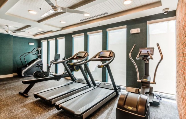 a gym with treadmills and other exercise equipment in a room