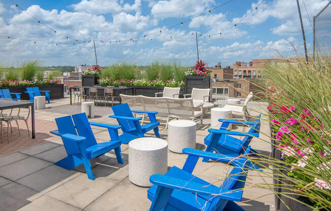 an outdoor patio with blue chairs and tables on a sunny day