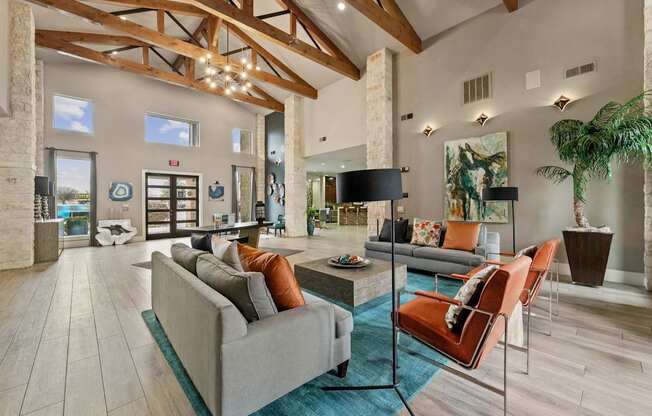 A living room with a grey couch and orange chairs.