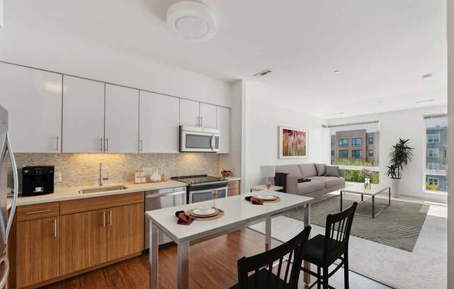 a kitchen and living room with a table and chairs at The Merc, Waltham, 02453