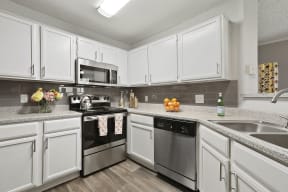 updated kitchen with stainless steel appliances and white cabinets
