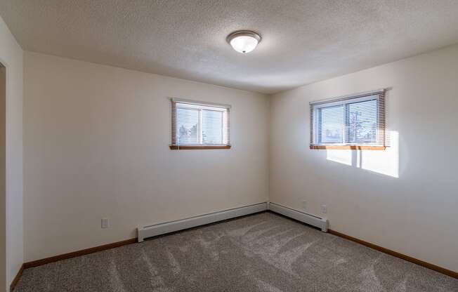 a bedroom with two windows. Fargo, ND North Manor Apartments