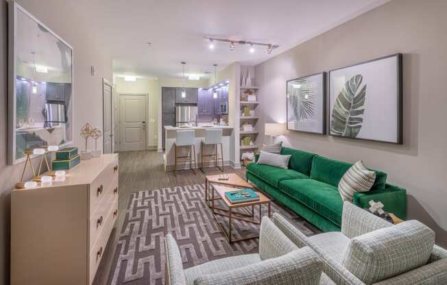 a living room and kitchen with a green couch