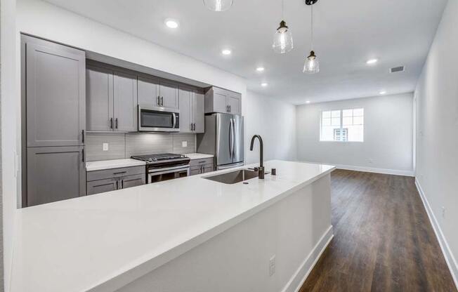 a kitchen with a sink and a stove in a house  at The Vineyards Apartments, California, 91326